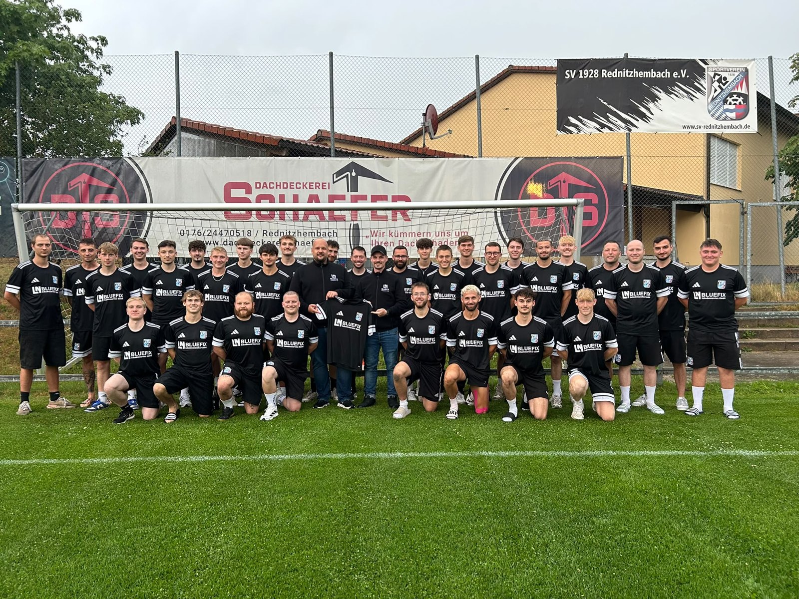 Fußballmannschaft des SV Rednitzhembach mit schwarzen Trikots und BLUEFIX-Sponsorenlogo